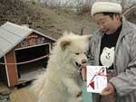 プレゼントされた新居の前で、飼い主の菊谷さんに甘える「わさお」