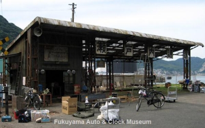 NHK土曜ドラマスペシャル「とんび」の撮影用に旧門司食糧倉庫敷地内に建てられた“瀬戸内通運備後支店”の車庫(9月25日、三輪トラック4台入庫直前の準備状況)【クリックで大きく表示】