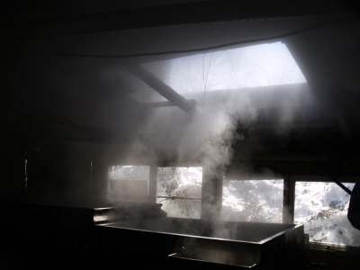 煮詰め小屋の中。40リットルの樹液で、1リットルのシロップにしかならない。この湯気、エステに使えないかな?