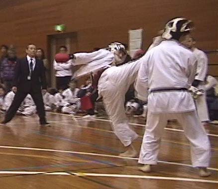 組手一般で優勝した三上選手の右ハイ。このくらい蹴り込んで得点となる。