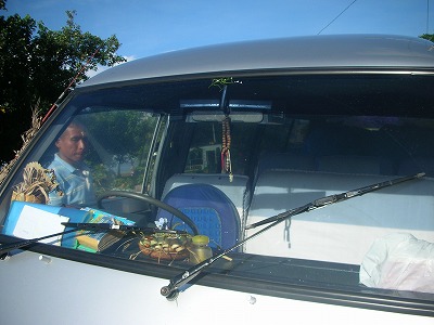 車にお供えをするスハさん。