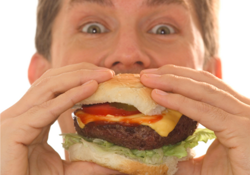 身体の噂・裏技・裏話_ハンバーガーを食べる男