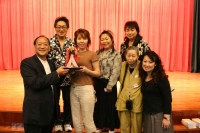 おみやげを持つ鎮長と出演者