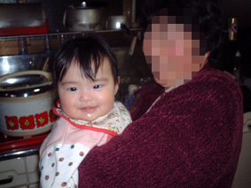 おばあちゃんに抱かれて笑顔