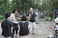 若い夫婦と膝の上にいる赤ちゃんに優しく演奏しています。