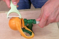柿皮むき器実演3…ハンドルを回しピーラーを当てがって皮をむく