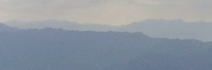 奥に薄っすらと見える山、左が三峰山で右が高見山