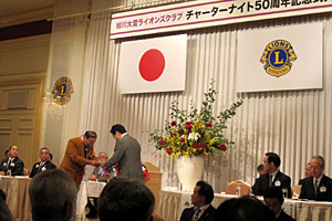 50周年記念アクティビティの目録を贈呈するL高橋(左)と西川将人旭川市長