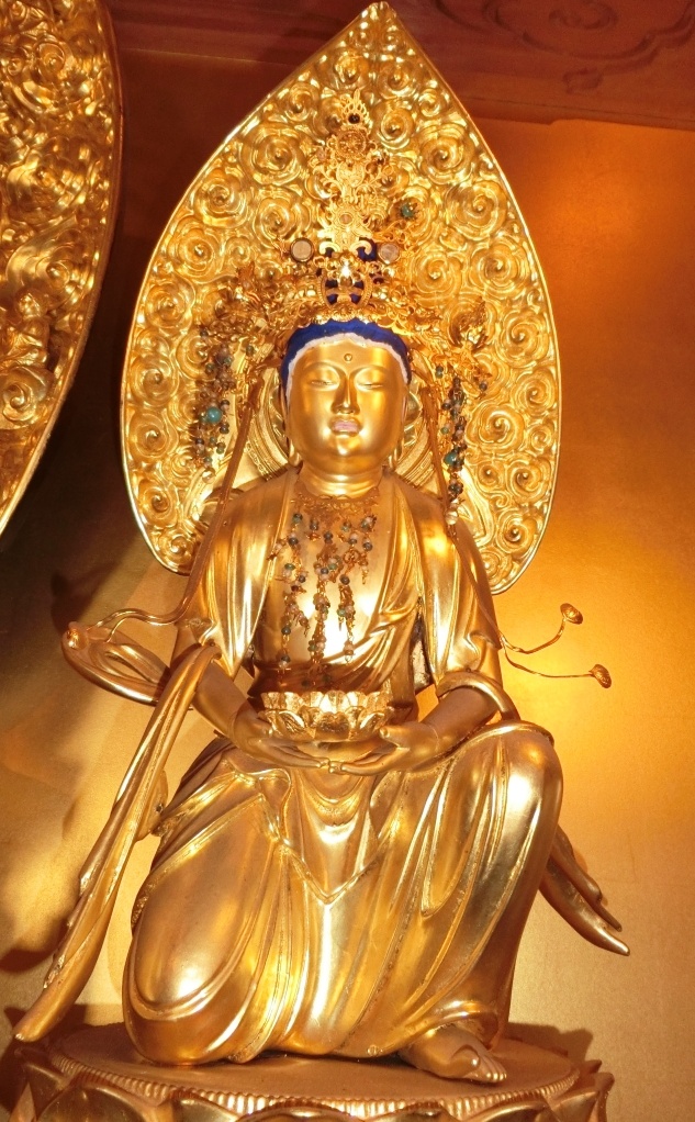 金色の座った仏像 蓮の花の台座付き