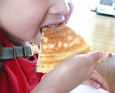 息子がホットケーキを食べている写真