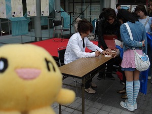 サインを書いている樋口さん