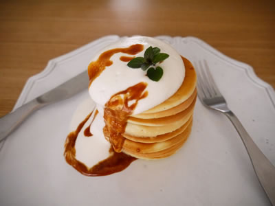 パンケーキタワーに生クリームとキャラメルソースをたっぷりかけて…。