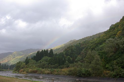 雨が降ったりやんだり。紅葉の始まった山に虹。