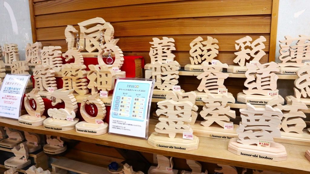 コーナー最上段の棚には木工品の漢字オブジェが多数展示されていました
