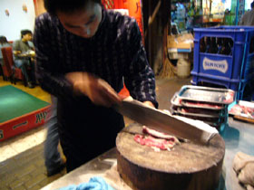 火鍋の具の羊肉を薄切りにする