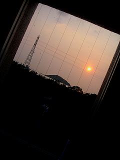 窓越しに見える笠山に沈む夕陽