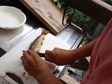川の恵みの魚をさばく