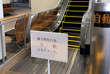 エスカレーター前に置かれた海上時化のため欠航の表示
