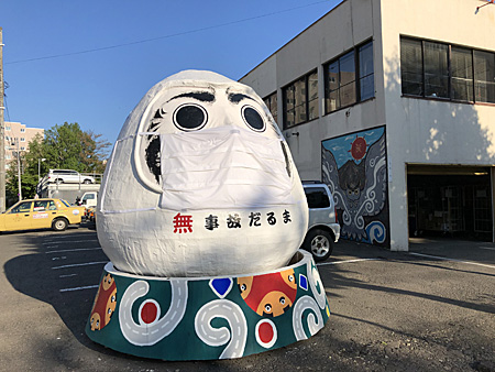 マスクをした巨大なダルマ