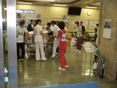 旧病院ホールに於いてベットから患者様をストレッチャーに担当職員により移乗中