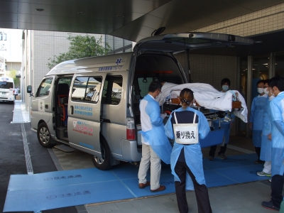 新病院の玄関へ感染症患者様を乗せた搬送車が到着