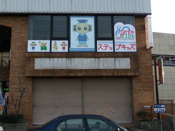 窓ガラスに印刷したシールを貼る 看板作りまSHOW